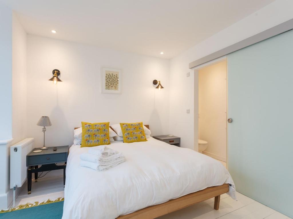 - une chambre avec un grand lit blanc et des oreillers jaunes dans l'établissement Dale House - Vivre Retreats, à Bournemouth