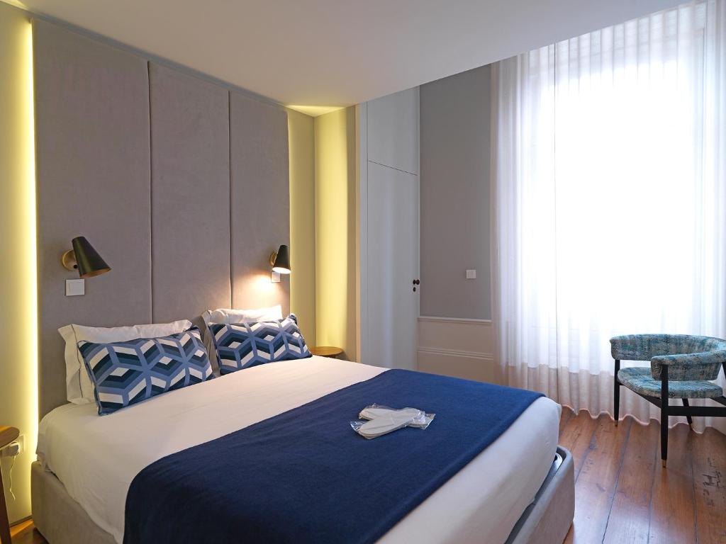 una camera da letto con un grande letto con una coperta blu di FLH New Oporto Apartments - Mouzinho a Porto
