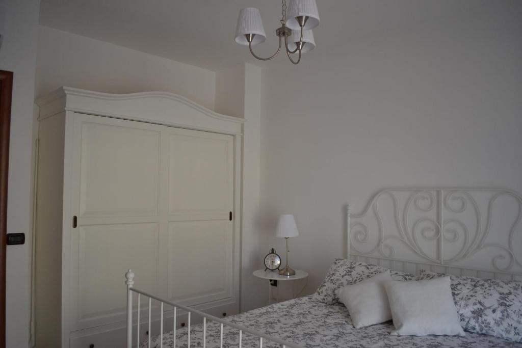ポンペイにあるVilla Country Chic Pompeiの白いベッドルーム(ベッド1台、シャンデリア付)