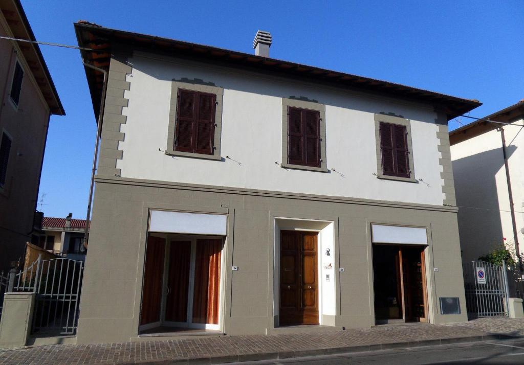 una casa bianca con finestre e porte su una strada di Affittacamere La Sosta a Pian di Scò