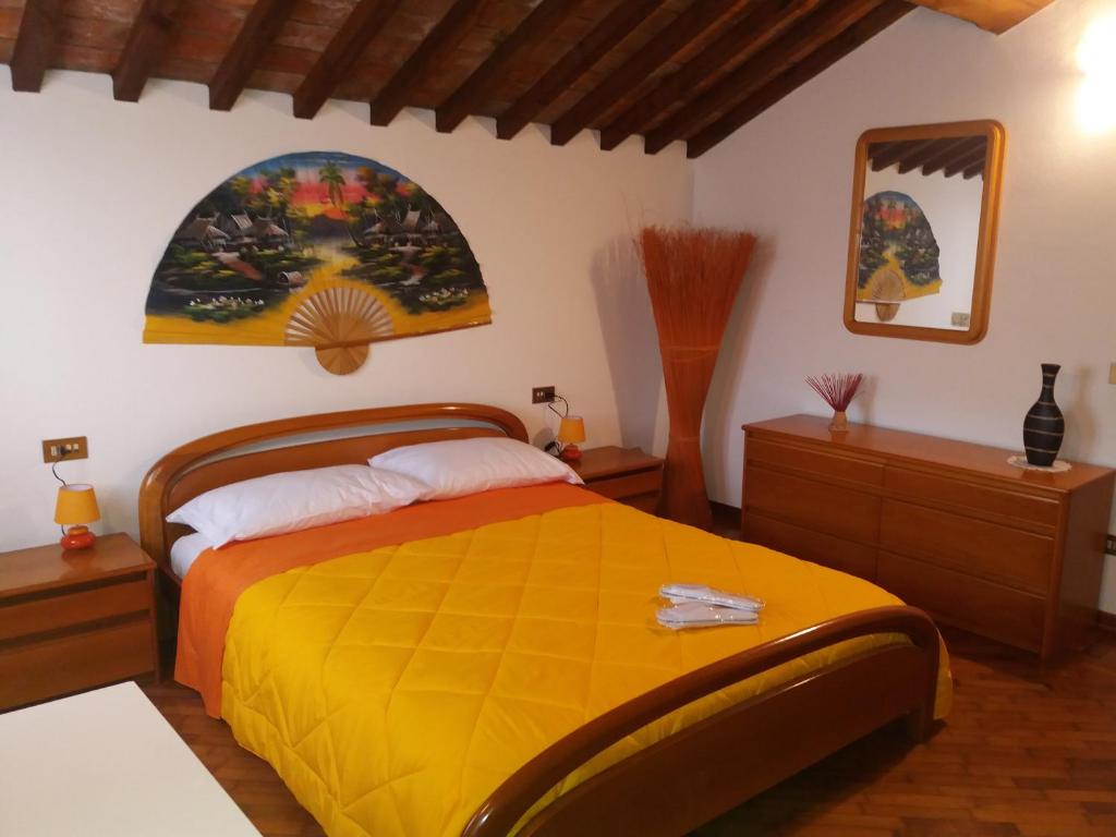 1 dormitorio con 1 cama y una pintura en la pared en R&B un mondo a colori, en Ferrara
