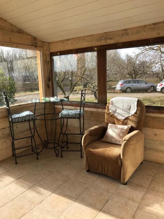 un porche cubierto con sillas y mesa en La Cabanes, en Senouillac