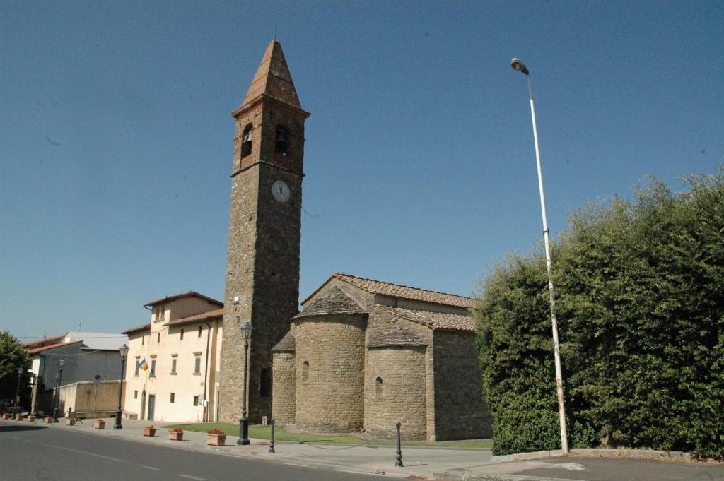 Un edificio con una torre alta e un orologio sopra. di Affittacamere La Sosta a Pian di Scò