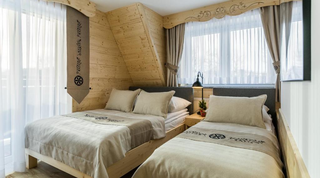 - 2 lits dans une chambre avec fenêtres dans l'établissement Pokoje Gościnne Chochołów, à Chochołów