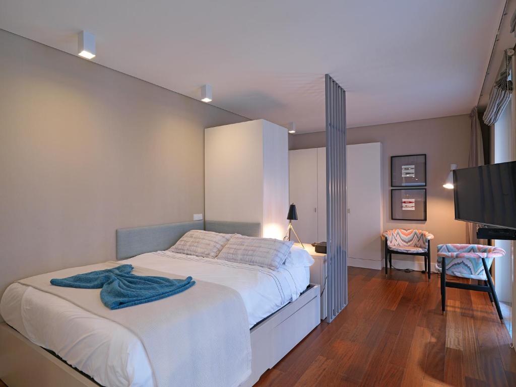 a bedroom with a large bed and a tv at New Oporto Apartments - Cardosas in Porto