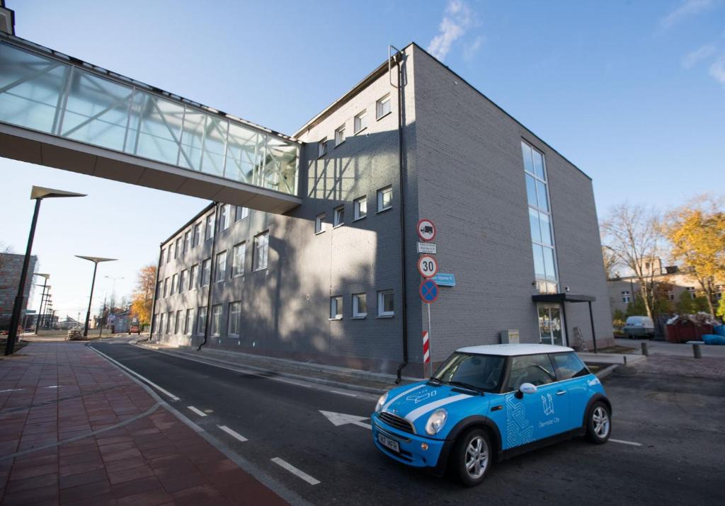 ein kleines blaues Auto, das vor einem Gebäude parkt in der Unterkunft Ülemiste Airport Hostel in Tallinn