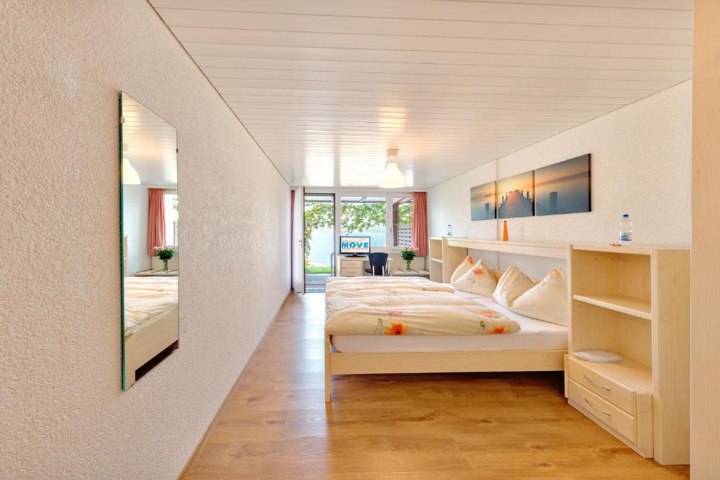 a large bedroom with two beds and a hallway at Hotel Restaurant Möve in Faulensee