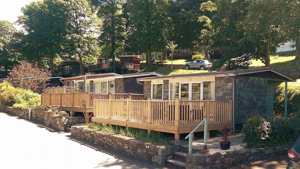 a house with wooden decks and a car at 147 Snowdon Drive, Glan Gwna in Caernarfon