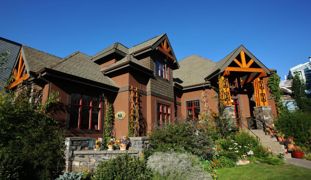 a large brown house with a garden in front of it at Buffaloberry Bed & Breakfast in Banff