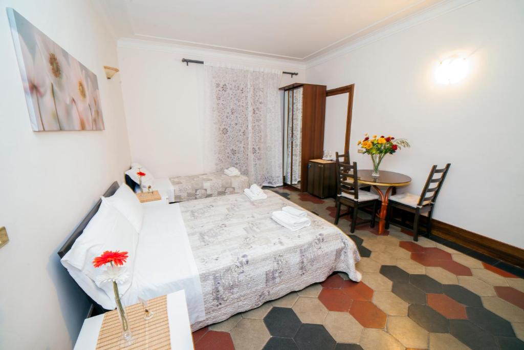 Schlafzimmer mit einem Bett, einem Tisch und Stühlen in der Unterkunft Ariana Luxury Guest House in Rom
