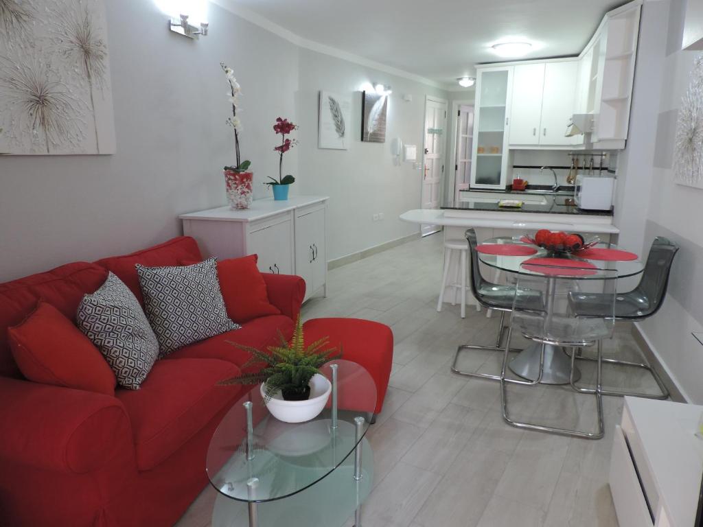 uma sala de estar com um sofá vermelho e uma mesa em Piso Puerto Naos a 1 Minuto de la Playa em Puerto Naos