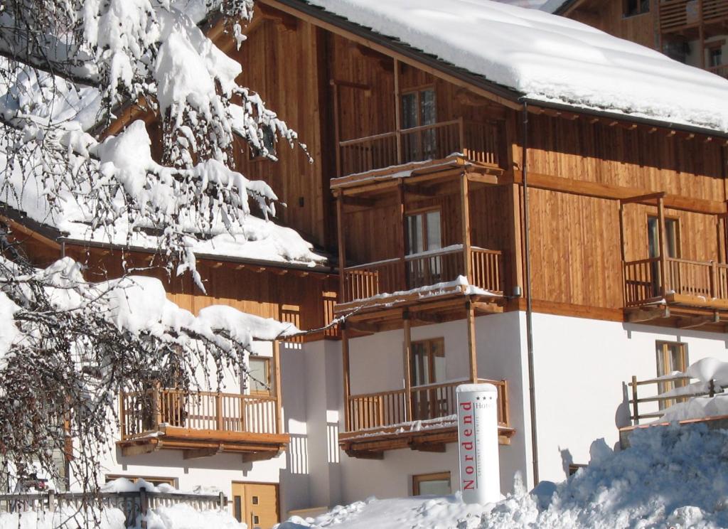 a building covered in snow with snow covered trees at Hotel Nordend in Gressoney-la-Trinité