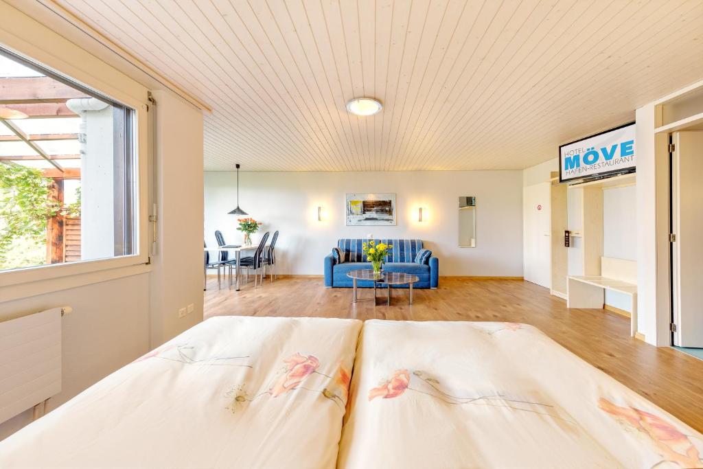 Un dormitorio con una cama y una sala de estar. en Hotel Restaurant Möve, en Faulensee