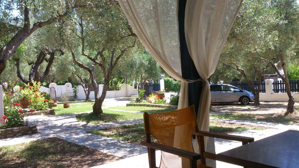una silla sentada frente a una ventana con árboles en Olive House, en Elia