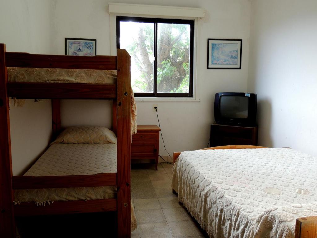 una camera da letto con due letti a castello e una televisione di Hotel Araucano a Mar de Ajó