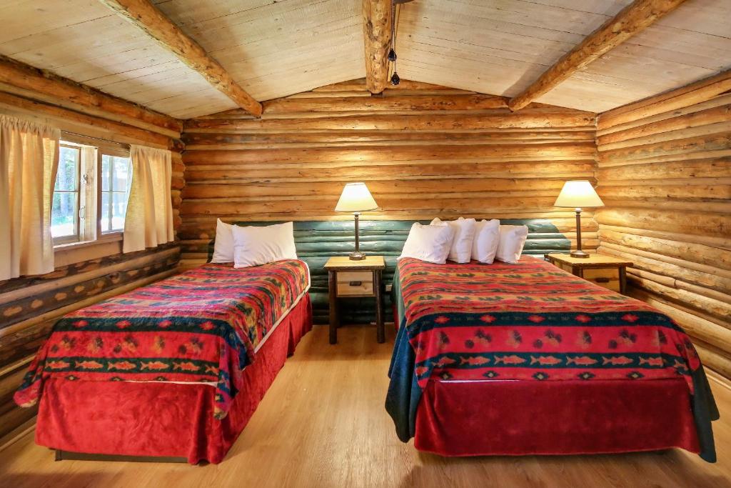 a bedroom with two beds in a log cabin at Colter Bay Village in Colter Bay Village