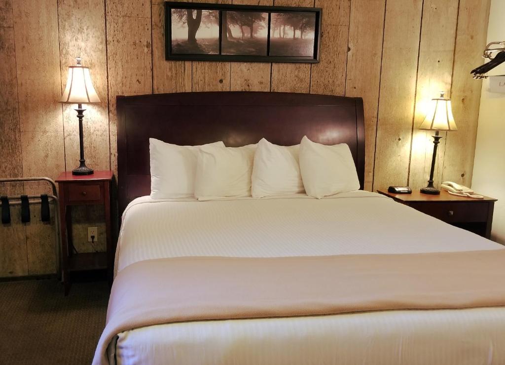 a bedroom with a large white bed with two lamps at Gold Pan Lodge in Quincy