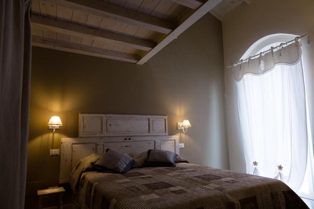 a bedroom with a bed and a large window at La corte dei tre in Torre del Lago Puccini