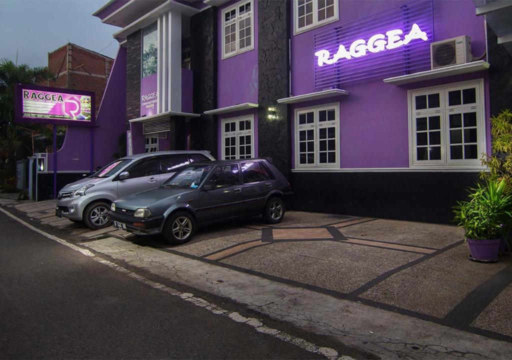 two cars parked in front of a purple building at Raggea in Malang