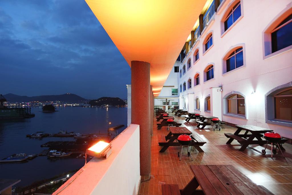 balkon budynku z widokiem na wodę w obiekcie Tongyeong Bay Condo Hotel w mieście Tongyeong