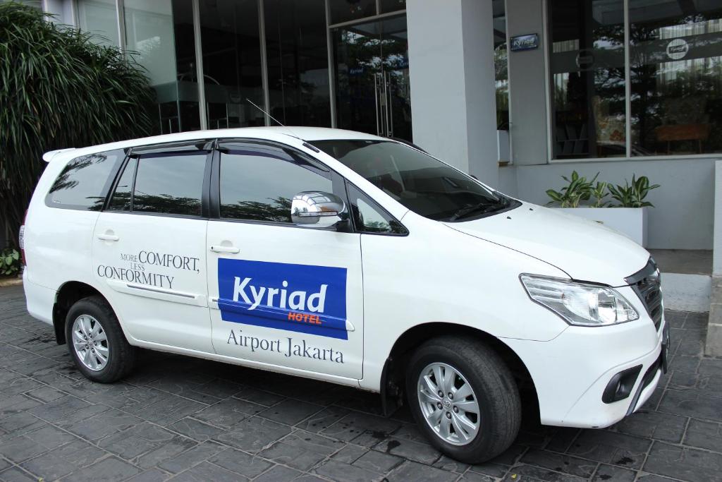 a white car parked in front of a building at Kyriad Hotel Airport Jakarta in Tangerang