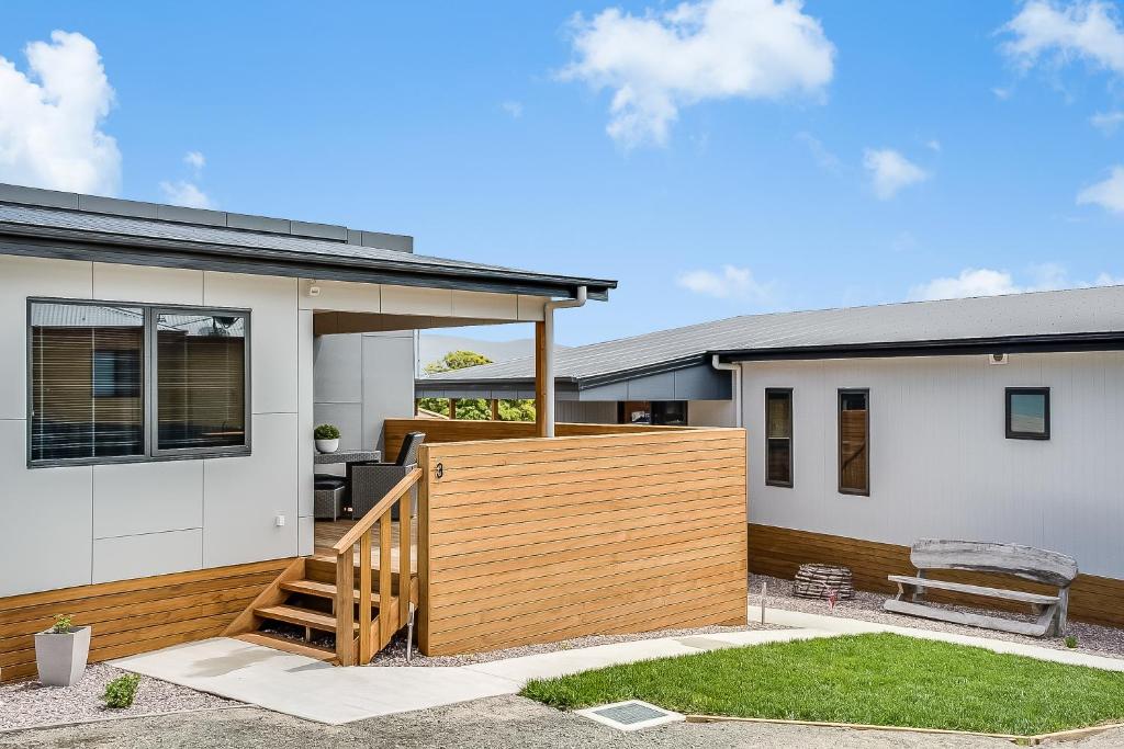 une maison avec une terrasse en bois devant elle dans l'établissement Apartments on Fraser Bicheno, à Bicheno