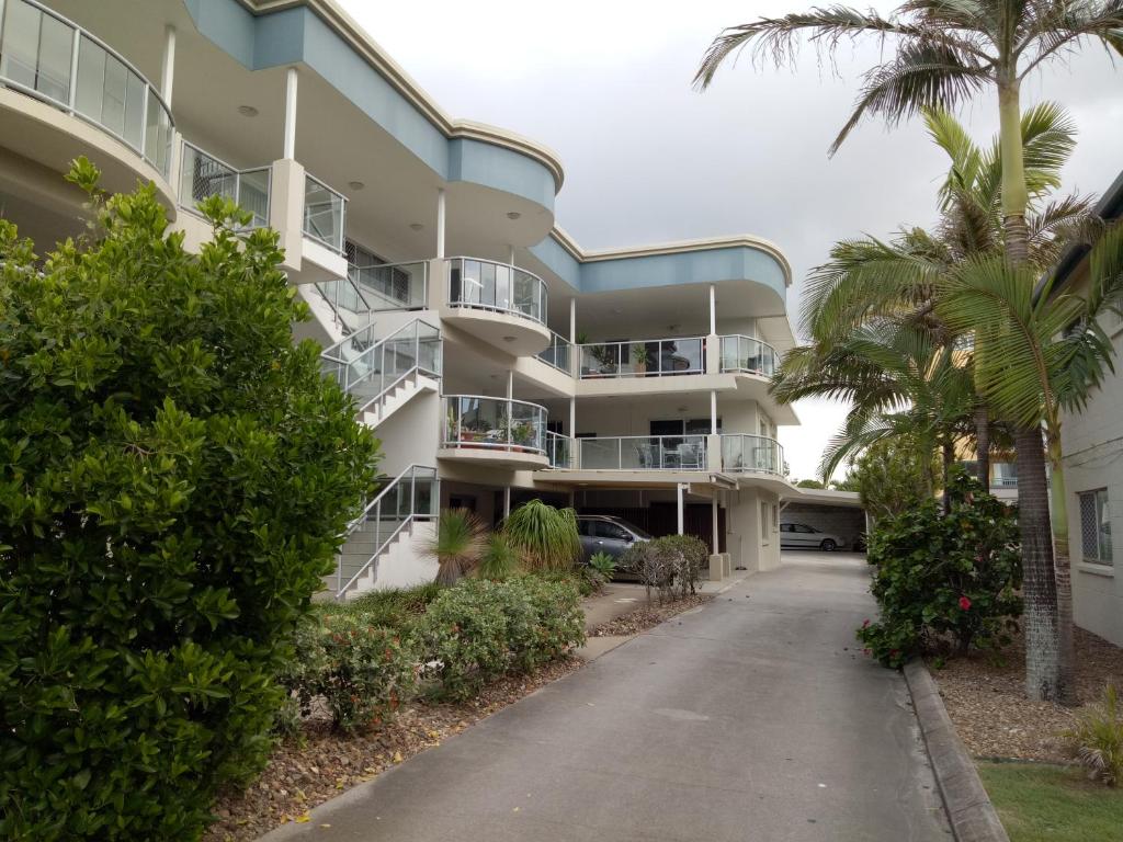 an apartment building with palm trees and a driveway at Cranbourne Court Beachside Apartments in Maroochydore