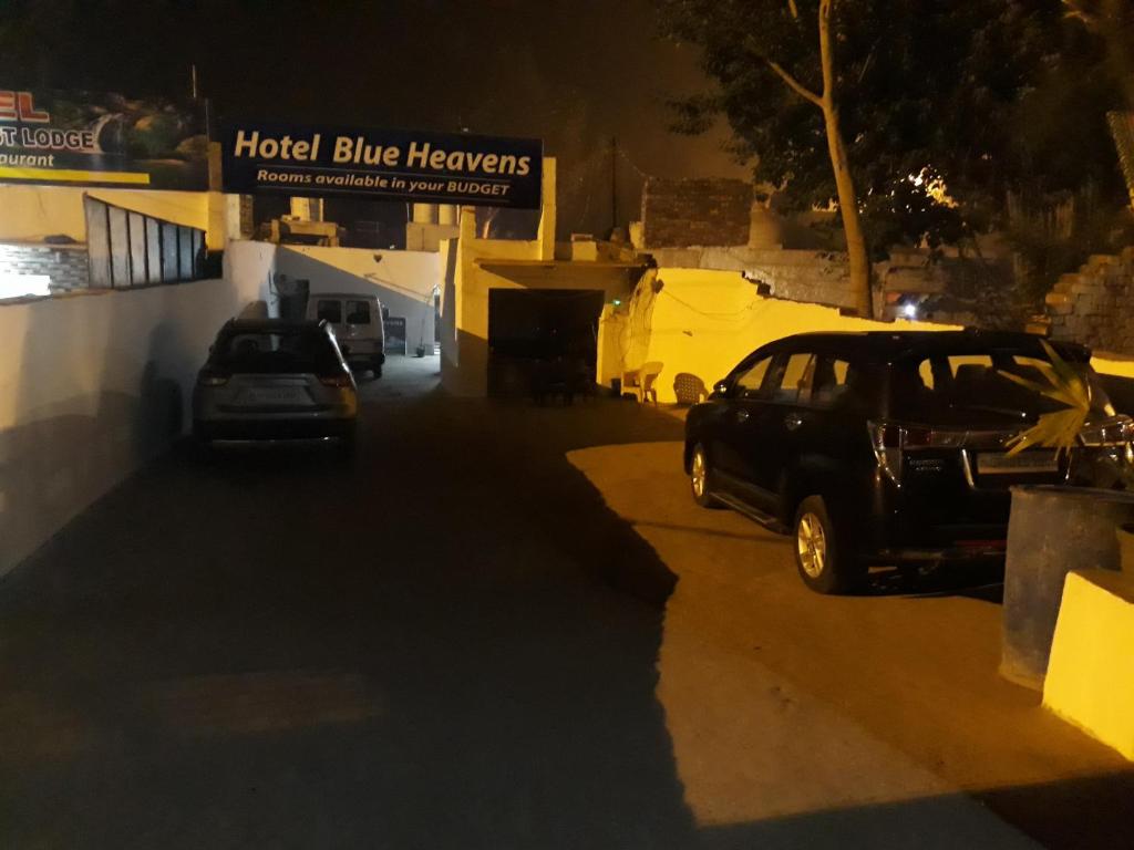 two cars parked in a parking lot at night at Hotel Blue Heaven in Fatehpur Sīkri