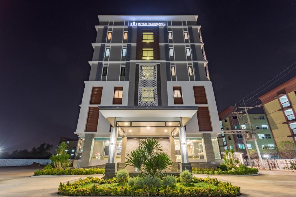 Samut Sakhon的住宿－Grand Inter Hotel，一座高大的建筑,晚上有灯