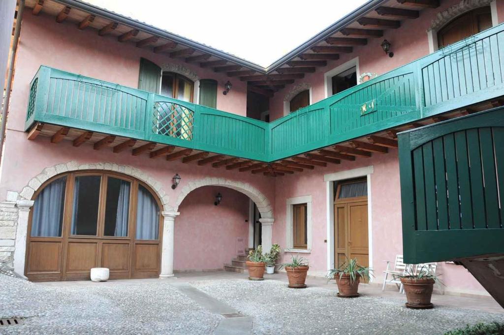una casa rosa con un balcone verde sopra di Hotel Sogno a Rezzato