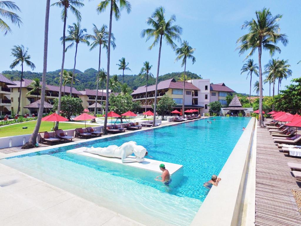 a man is swimming in a pool with a surfboard at The Emerald Cove Koh Chang in Ko Chang