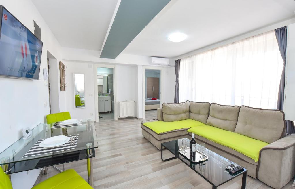 a living room with a couch and a tv at Harmony Suites in Bucharest