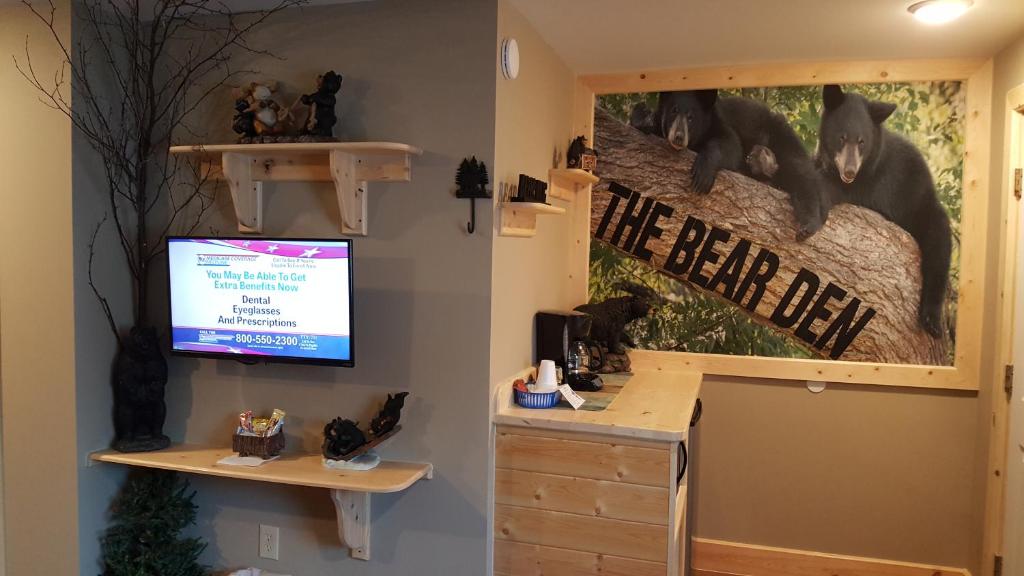 a room with a desk and a tv on a wall at Bear Cove Inn in Saint Ignace