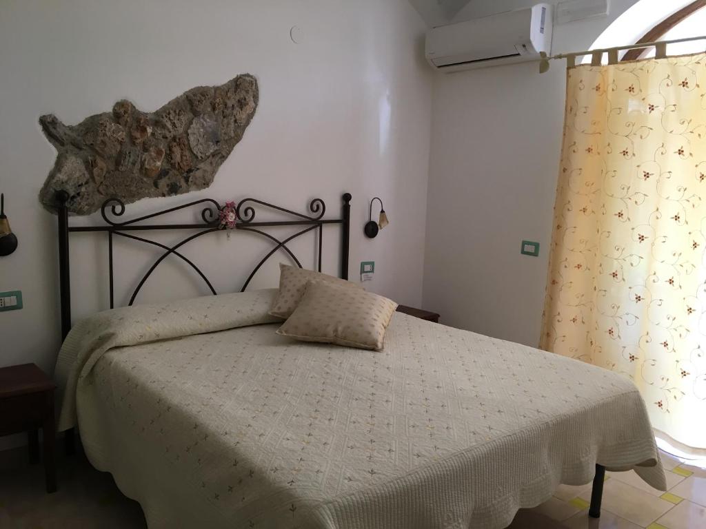 a bedroom with a bed with a white comforter at Luna D'Agerola in Agerola