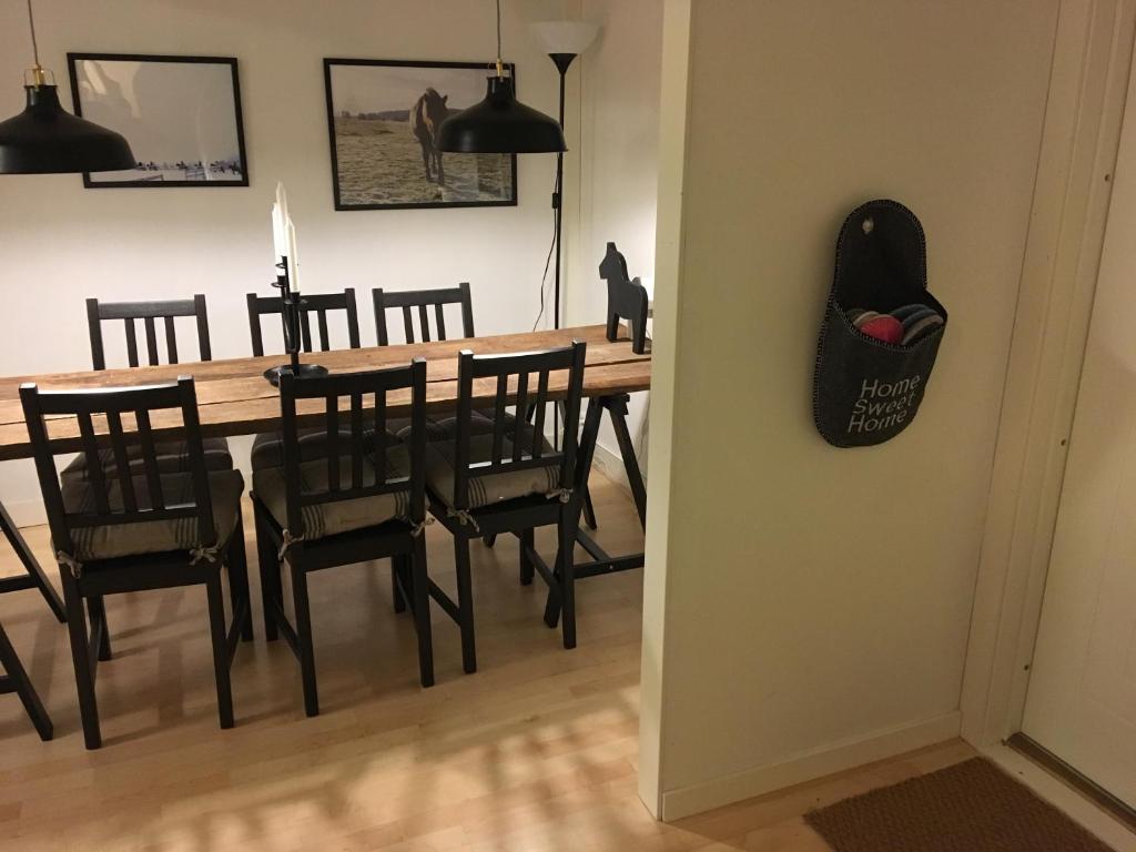 Lilla Vrån في Lerbäcken: طاولة غرفة طعام مع كراسي ورأس قطة على الحائط