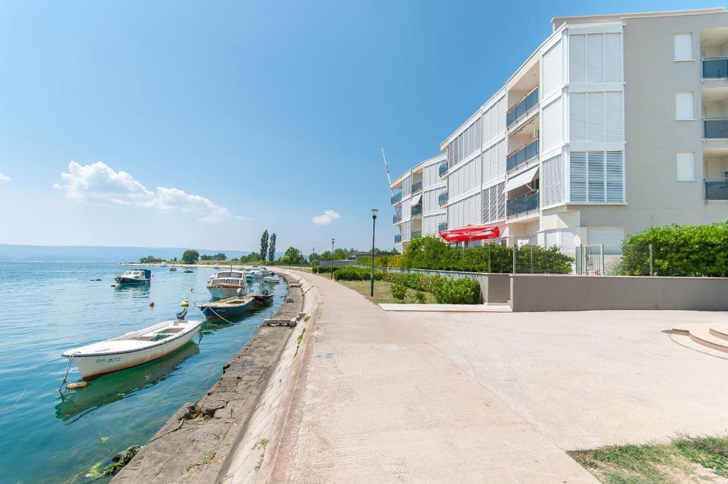 una fila de barcos en el agua al lado de un edificio en AP 6+2 in one of the most luxury building in Omis, en Omiš