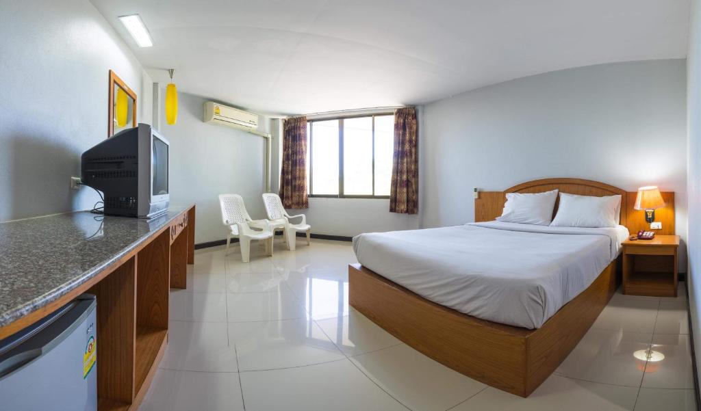 um quarto de hotel com uma cama e uma televisão em Sport Inn em Chiang Rai