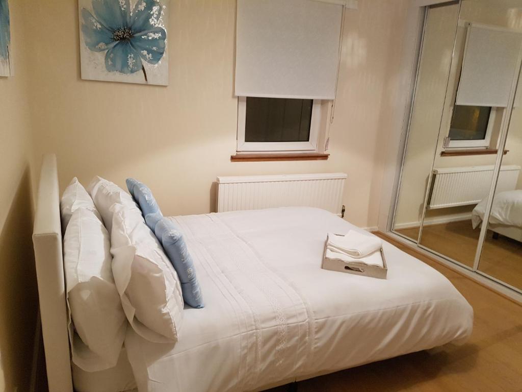 Un dormitorio con una cama con un libro. en Linlithgow Loch Apartment en Linlithgow