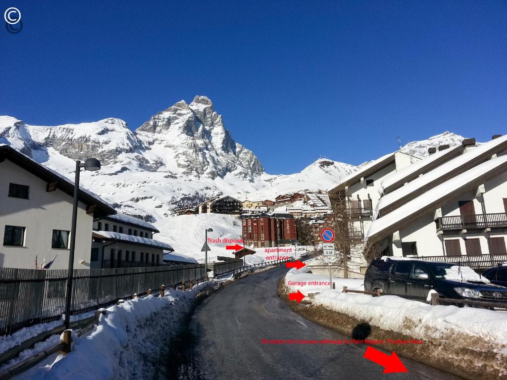 a street with snow covered mountains in the background at Breuil Cervinia Funicular House with Private Garage in Breuil-Cervinia