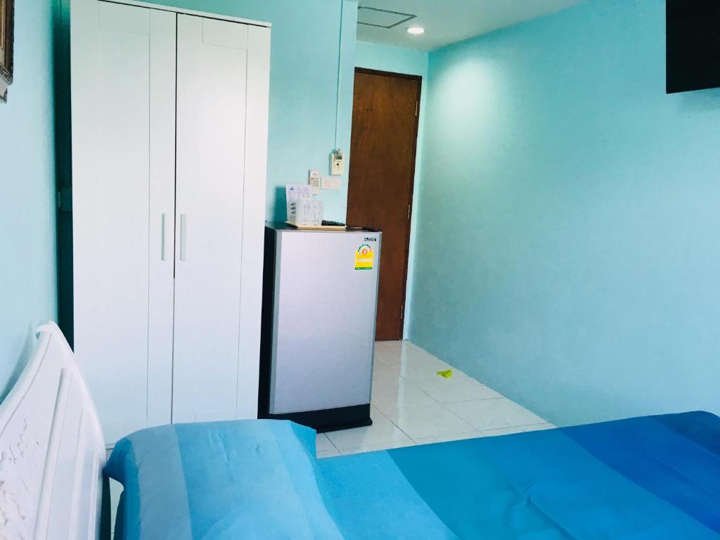 a room with a refrigerator and a blue wall at Best Rent a Room in Nai Yang Beach