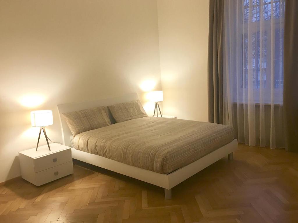 una camera da letto con un letto con due lampade sopra di Appartamento Nadia a Merano
