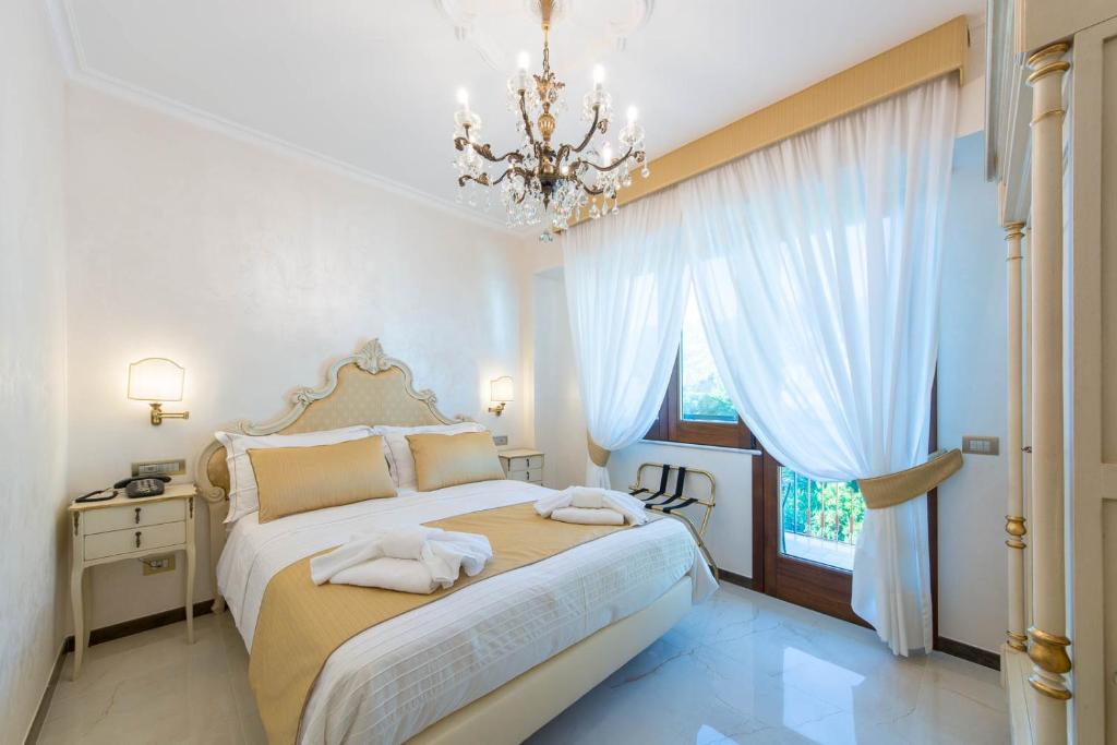 a bedroom with a bed and a chandelier at B&B Palazzo Montesanto in Maiori