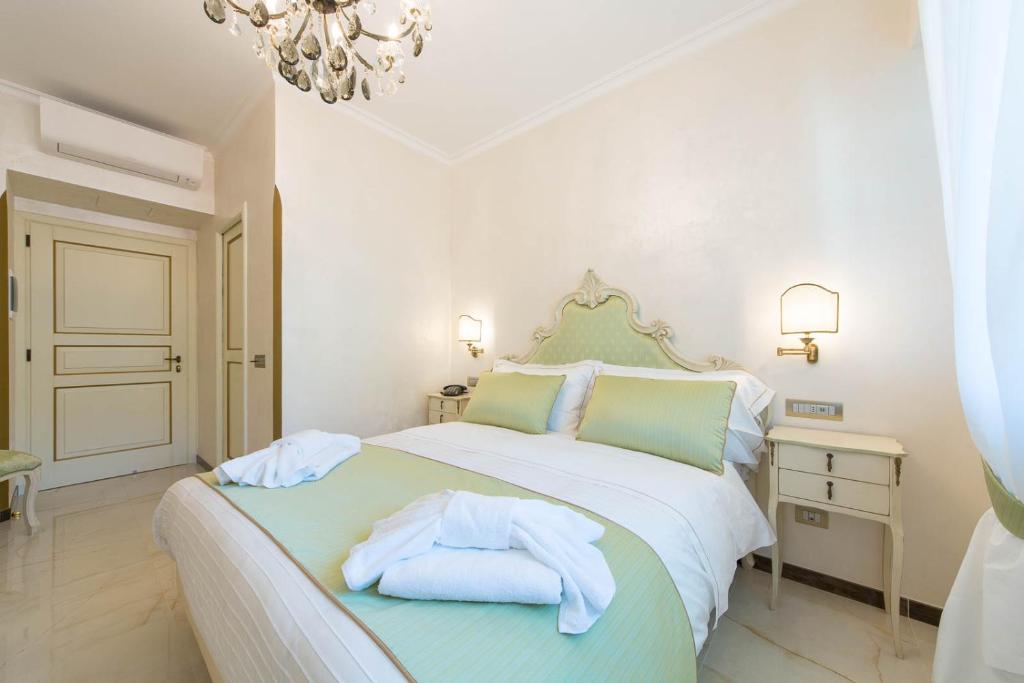a white bedroom with a bed with towels on it at B&B Palazzo Montesanto in Maiori