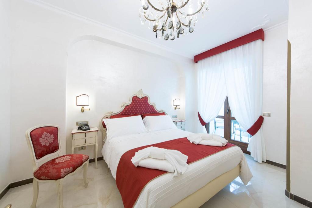 a bedroom with a red and white bed and a chandelier at B&B Palazzo Montesanto in Maiori