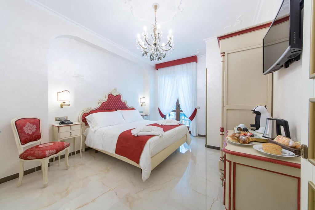 a bedroom with a large bed and a chandelier at B&B Palazzo Montesanto in Maiori