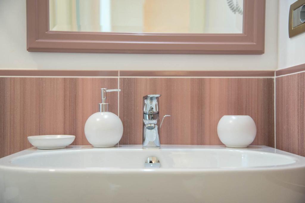 a bathroom sink with two vases on top of it at B&B Palazzo Montesanto in Maiori