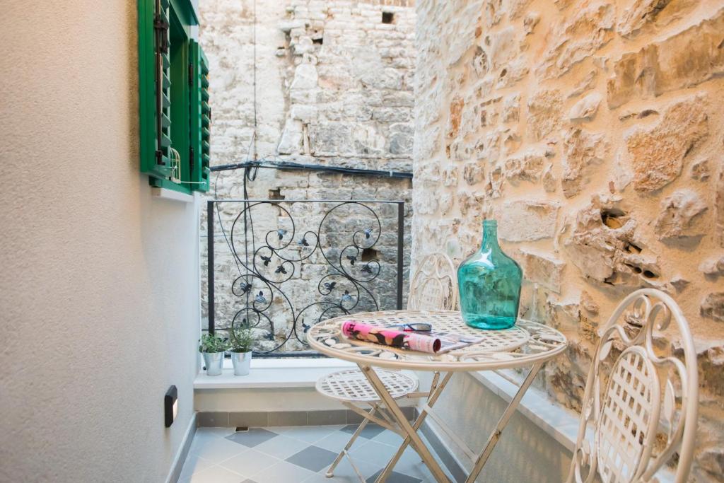 a small table with a glass vase on a window at Residence Teatro in Šibenik