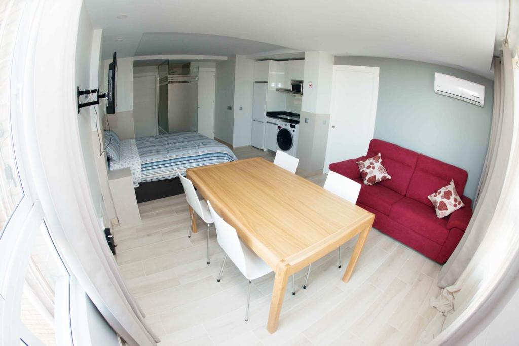 salon z drewnianym stołem i czerwoną kanapą w obiekcie Modern & Stylish Loft with Breathtaking Views FREE WIFI - Close to the sea w Maladze