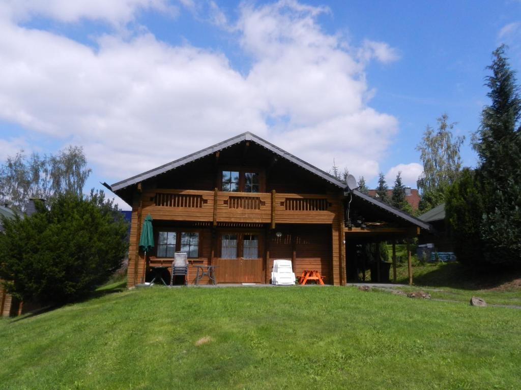 una cabaña de madera con un césped verde delante de ella en Family 9, en Ulmen