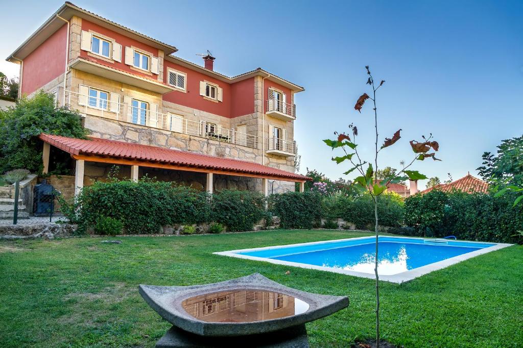 une grande maison avec une piscine dans la cour dans l'établissement Casa da Oliveira, à Mondim de Basto